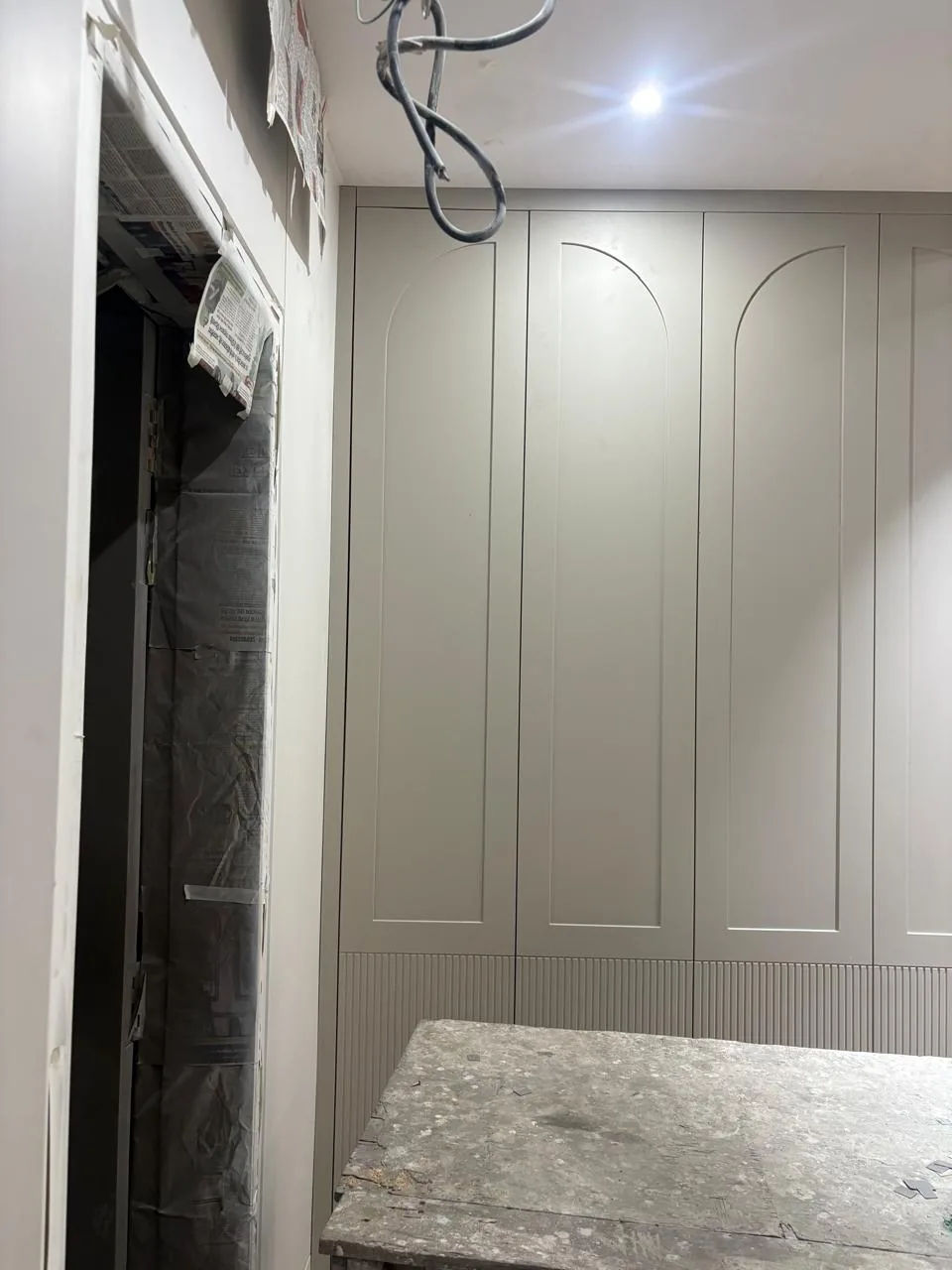 Custom wardrobe fitted while final electrical work remains visible