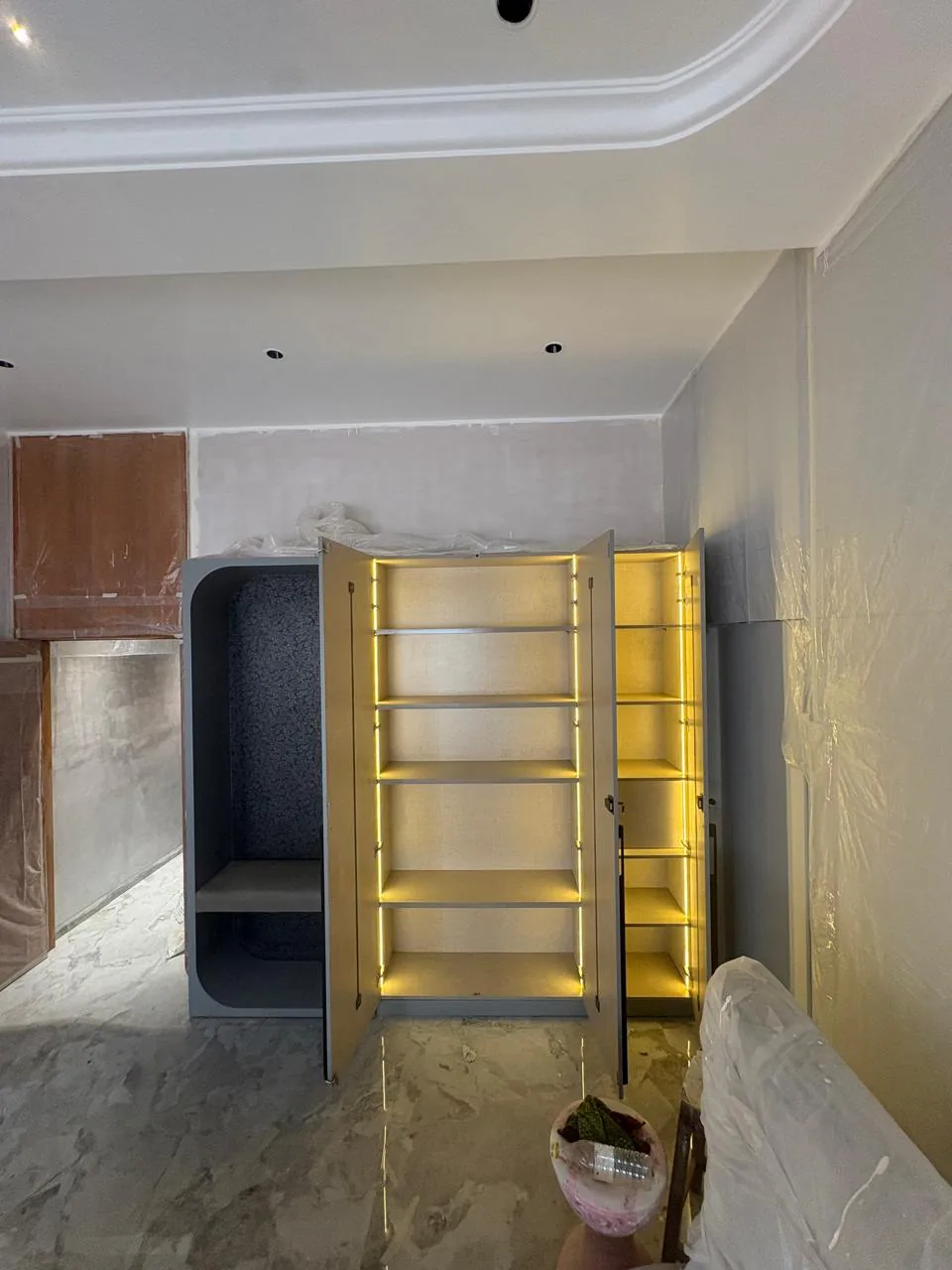 Tall illuminated cabinet during installation
